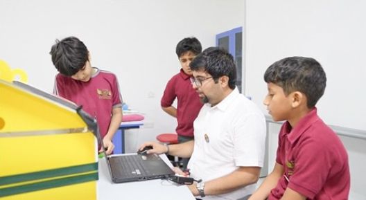 Students discovering coding alongside their mentor (Oman)
